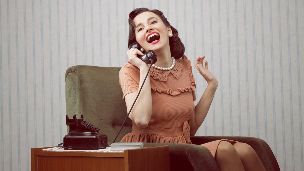 Femme souriante assise dans un fauteuil et parlant au téléphone