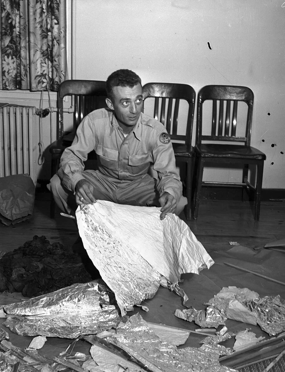Photographie d’archives de Jesse Marcel tenant une feuille de matériau parmi des débris présentés à Fort Worth le 8 juillet 1947.