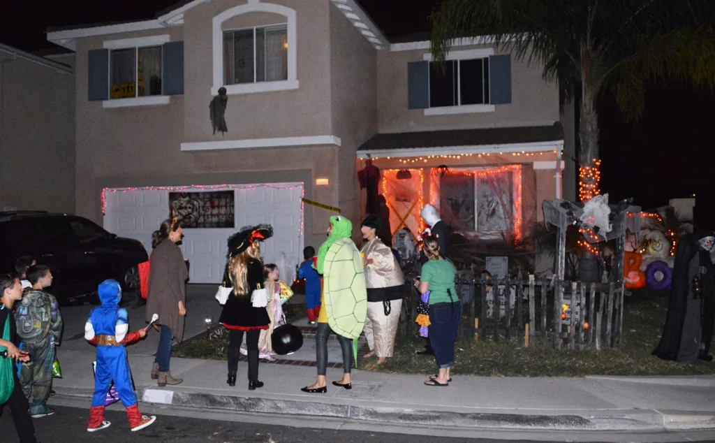 Des enfants déguisés avec leurs sacs à bonbons devant une maison décorée pour Halloween à Rancho Santa Margarita, en Californie