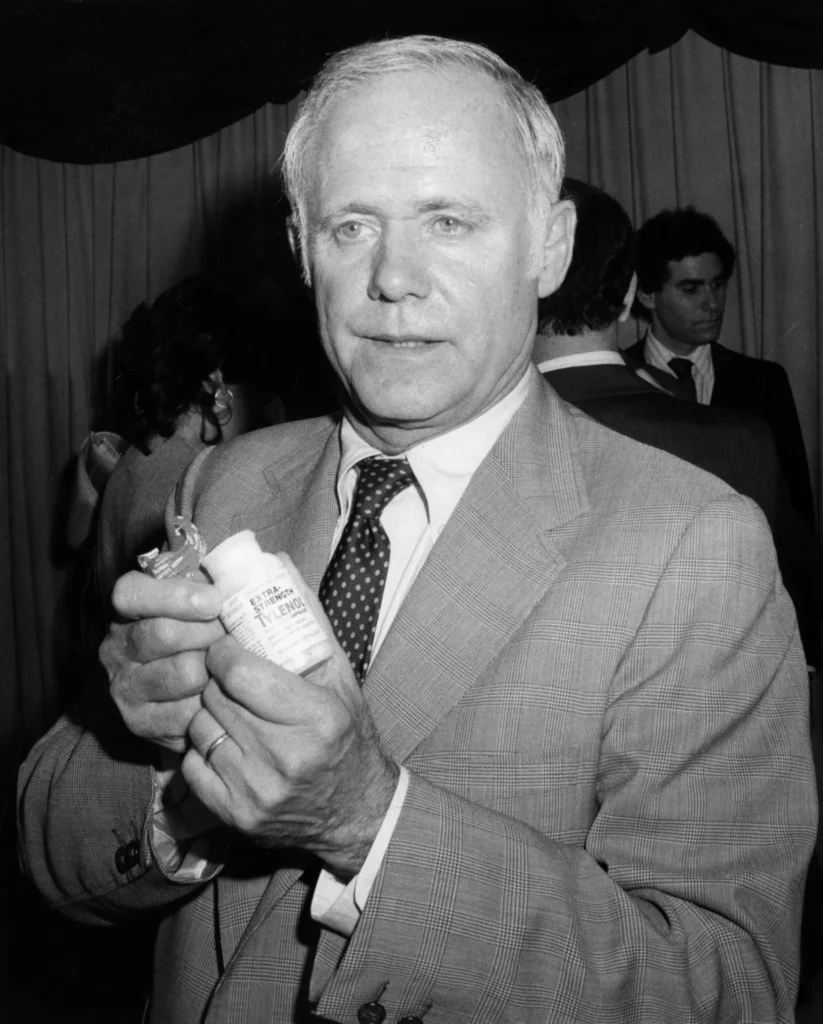 James E. Burke présente un flacon de Tylenol en 1982