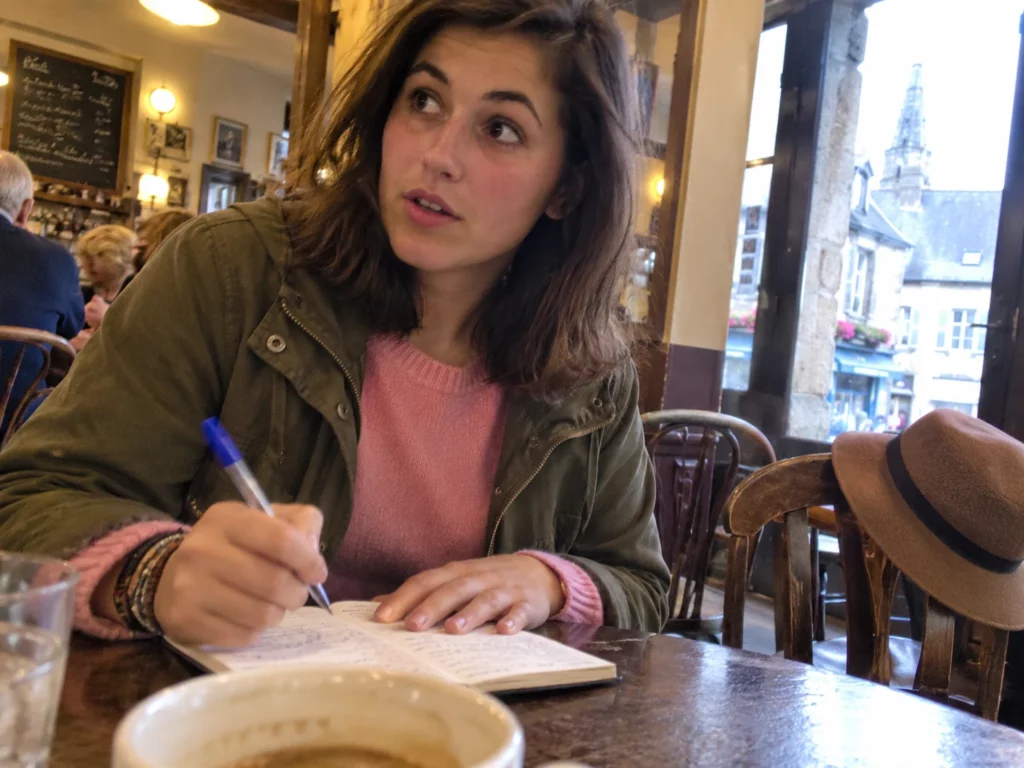 Claire prend des notes dans un café de village